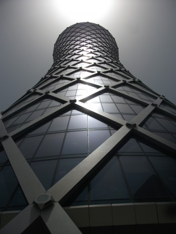 Skyscraper Light, Doha, Qatar, 2011, Inkjet Print on Hahnemule Fine Art Paper, 20 x 24 inches, edition of 10.   One of the many beautiful new skyscrapers in Doha, the capital of Qatar.  This building appears to have a light shooting from its top floor, in a solar abstraction, almost as if it has become a kind of gargantuan flashlight of many hundreds of feet height.  It appears to not be real.  But it is real.  Qatar borders Saudi Arabia and the Persian Gulf and has the highest per-capita income of any nation in the world. 